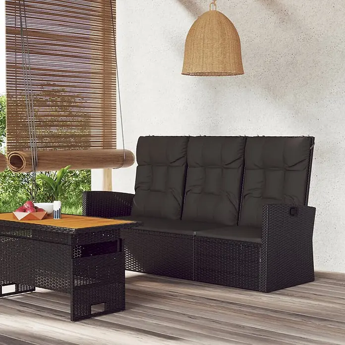 Furnicato Gartenbank - Schwarz - Schwarzes Rattan-Sofa mit passendem Beistelltisch, dunklen Kissen und Holzplatte, auf einer Terrasse.