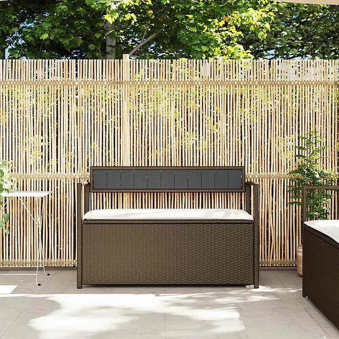 Furnicato Gartenbank PE-Rattan - B x T x H: 111,5 x 54 x 74 cm, Braun und Cremeweiß - Braune Rattan-Gartenbank mit weißem Kissen und grauer Rückenlehne auf einer Terrasse.