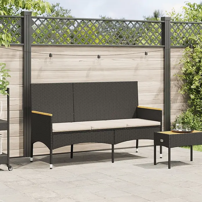 Furnicato Gartenbank PE-Rattan - B x T x H: 140 x 54 x 85 cm, Schwarz - Schwarze Rattan-Gartenbank mit beigefarbenen Kissen und passendem Beistelltisch auf einer Terrasse.