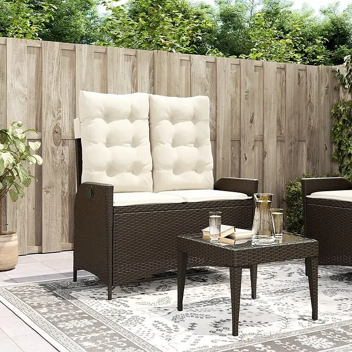 Furnicato Gartenbank - B x T x H: 59 x 86 x 93 cm, Braun und Creme - Dunkelbraune Rattan-Gartenbank mit cremefarbenen Kissen und passendem Tisch auf einer Terrasse.