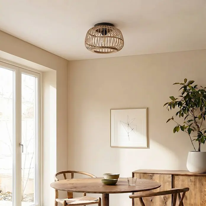 Lindby Deckenleuchte Bominio - L x B x H: 40 x 40 x 24,5 cm, Holz hell, E27 - Runde Deckenleuchte mit natürlichem Rattan-Käfigschirm und schwarzer Basis, in einem Esszimmer installiert.