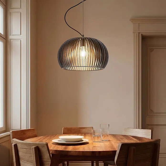 Lindby Pendelleuchte Jusra - schwarz, Schwarz, E27 - Dunkle Lamellen-Pendelleuchte mit sichtbarer Glühbirne, über einem runden Holztisch hängend.