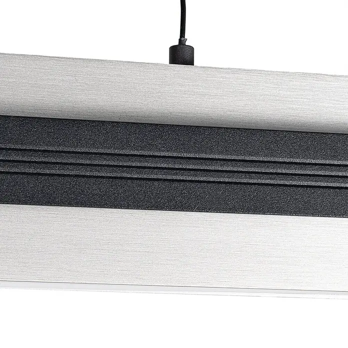 Lucande Pendelleuchte Tarnin - L x B x H: 98 x 7 x 8 cm, schwarz, Schwarz, nickel - Nahaufnahme einer linearen Leuchte aus gebürstetem Silbermetall mit strukturierter dunkelgrauer Mittelplatte mit Rillen und schwarzem Kabel.