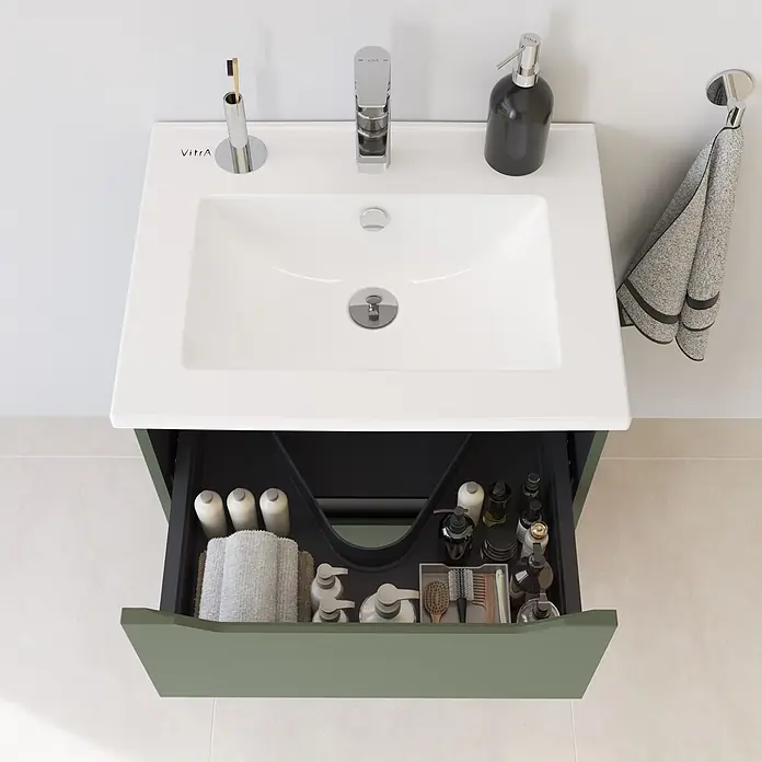 VitrA Integra Square Badmöbel-Set - Gesamtbreite Badmöbel: 60 cm, Moosgrün, Matt - Weißes Waschbecken mit Chromarmatur und geöffneter grüner Waschtischschublade mit organisierten Toilettenartikeln.