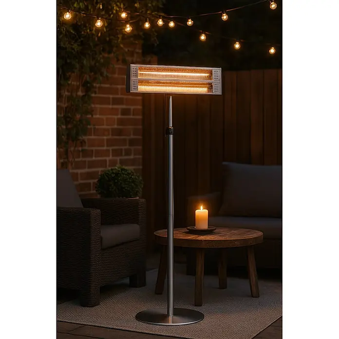 WDH Heizlüfter -  - Silberner Terrassenheizstrahler auf Standfuß, mit glühenden Heizelementen, spendet Wärme auf der Terrasse bei Nacht.