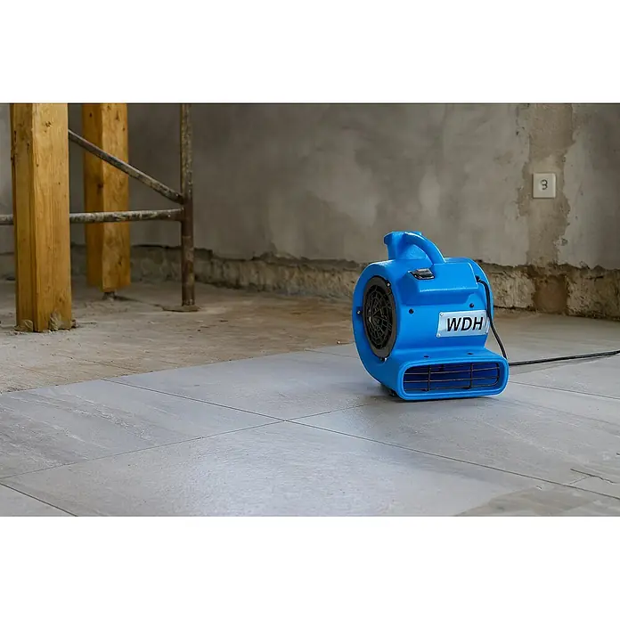 WDH Bodenventilator Mini Turbolüfter WDH-C20 -  - Blauer WDH Bodentrockner in einem Bau- oder Sanierungsbereich, auf hellgrauen Fliesen stehend.