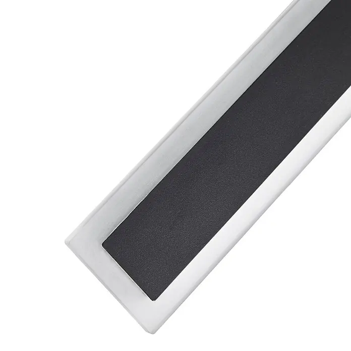 Lucande Außenwandleuchte Ilora - 3,9 x 8 x 60 cm, schwarz, schwarz, IP65 - Rechteckiger Anti-Rutsch-Streifen mit dunkler, texturierter Oberfläche in einem hellen Metall- oder Kunststoffrahmen.