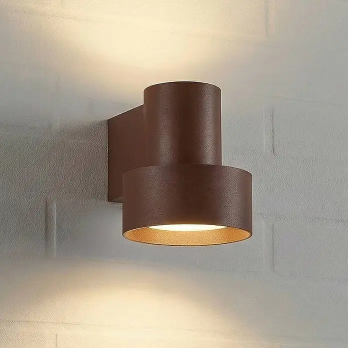 Lucande Außenwandleuchte Elune - braun / rost, IP44 - Eine braune zylindrische Wandleuchte, die warmes Licht nach oben und unten abstrahlt.