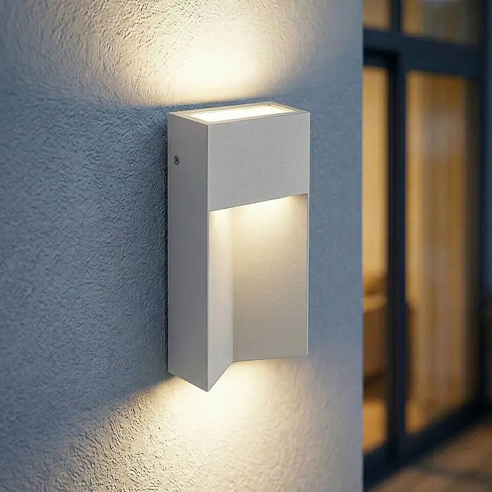 Lucande Außenwandleuchte Kaholo - alu / grau / zink, alu / grau / zink, IP44 - Weiße Up-Down-Wandleuchte an strukturierter Wand, die warmes Licht nach oben und unten abgibt.