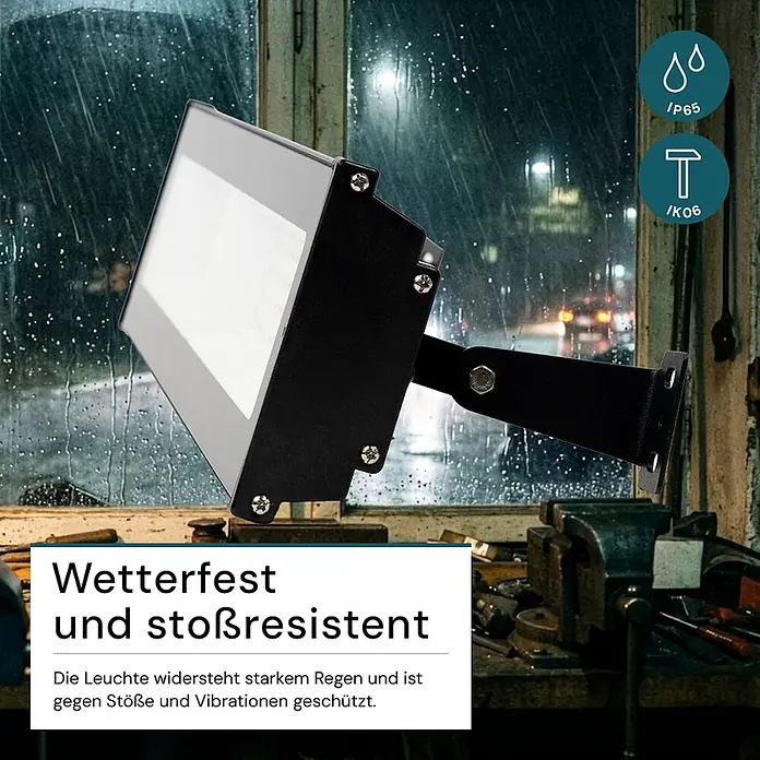 Luxula LED-Strahler LED-Hallenstrahler - 100 W, 10.000 lm, 4.000 K, L x B x H: 513 x 124 x 46 mm, IP65 - Schwarzer und grauer LED-Fluter mit heller Leuchtfläche, draußen im Regen montiert. Er ist wetterfest (IP65) und stoßfest (IK06).