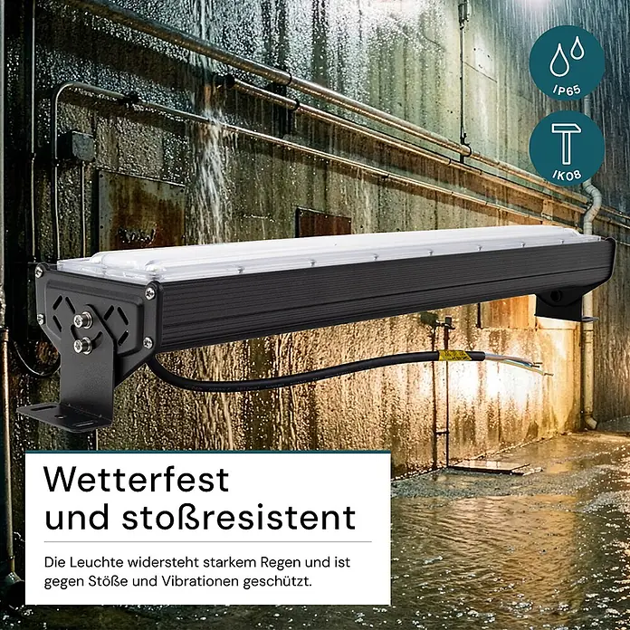 Luxula LED-Strahler LED-Hallenstrahler - 50 W, 6.000 lm, 5.000 K, L x B x H: 285 x 118 x 78 mm, IP65 - Schwarze, robuste LED-Leuchtleiste an einer nassen Industriewand, die ihre Wetter- und Stoßfestigkeit demonstriert.