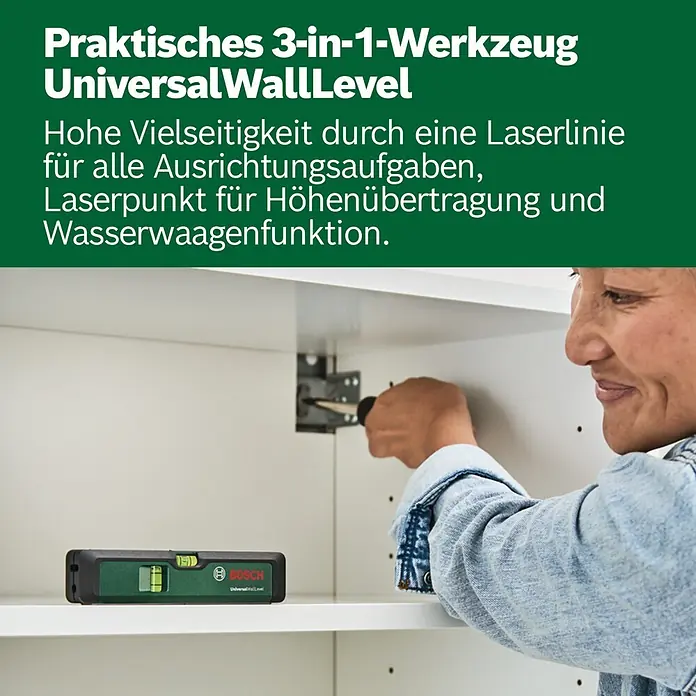 Bosch Kreuzlinienlaser Advanced Level 2G Set - Max. Arbeitsbereich: 15 m - Eine Person verwendet eine grüne und schwarze Bosch UniversalWallLevel zur Installation in einem weißen Schrank.
