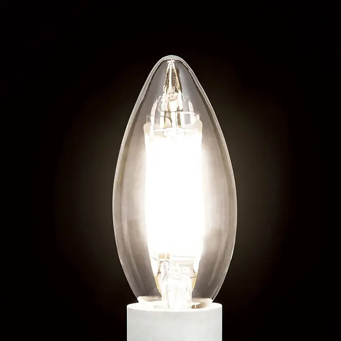 Orion Leuchten LED-Lampe - E14, Dimmbar, Warmweiß, 450 lm, 4,5 W - Eine beleuchtete, kerzenförmige Glühbirne aus Klarglas mit weißem Sockel.
