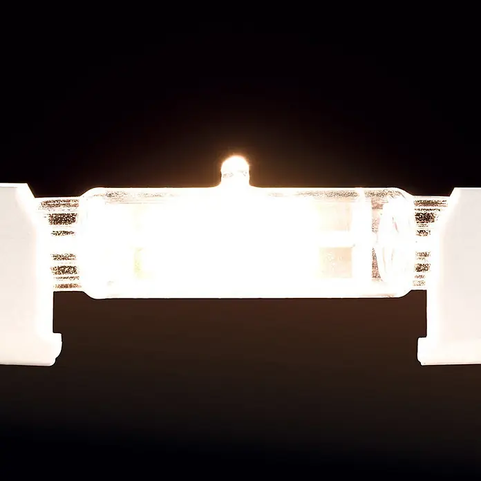 Orion Leuchten LED-Lampe - R7s, Nicht Dimmbar, Warmweiß, 450 lm, 4 W - Helles Segment einer LED-Lichtleiste mit klarem Gehäuse und weißen Anschlüssen, warmweißes Licht emittierend.