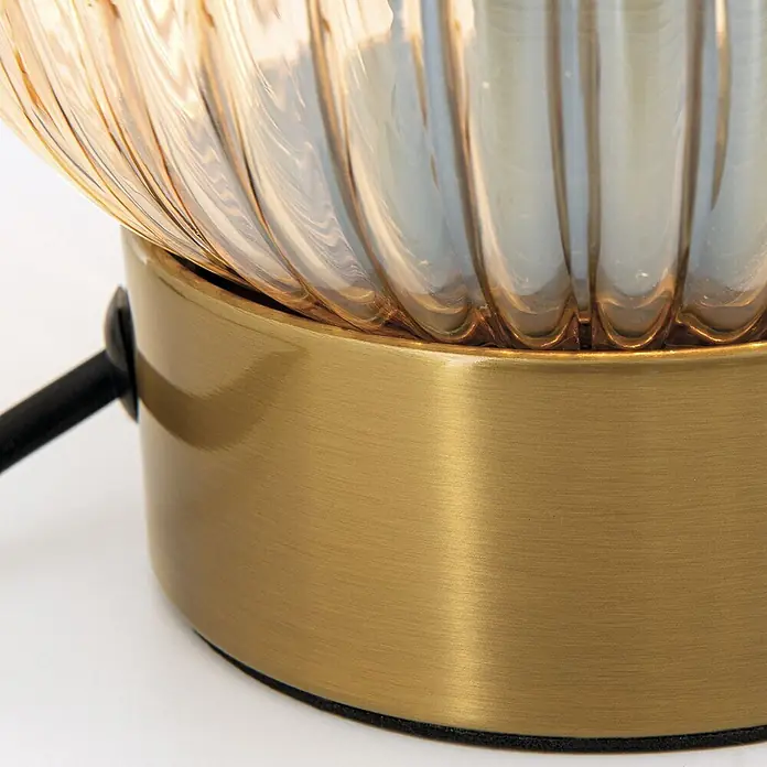 Orion Leuchten Tischleuchte - 40 W, L x B x H: 14 x 14 x 24 cm, E27 - Nahaufnahme einer Lampe mit gebürstetem Messingsockel und geripptem bernsteinfarbenem Glasschirm.