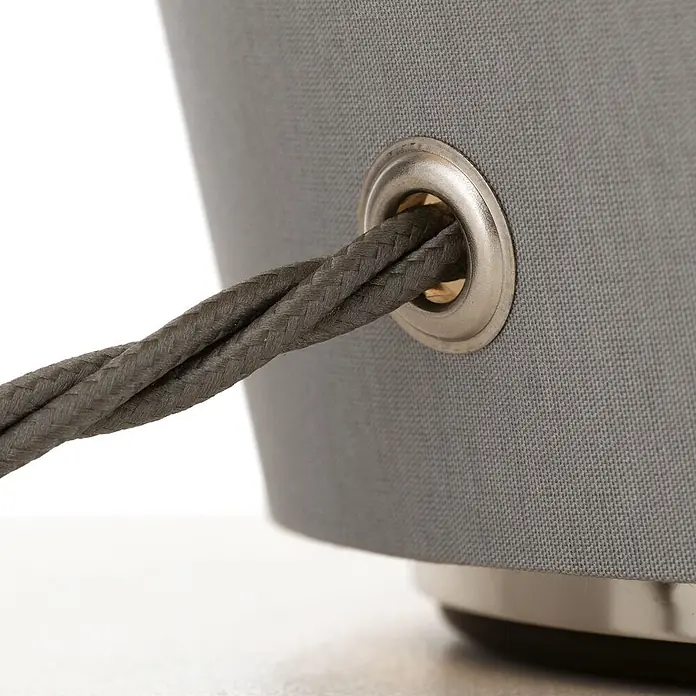 Orion Leuchten Tischleuchte - 40 W, L x B x H: 32 x 32 x 41 cm, E27 - Nahaufnahme eines geflochtenen grauen Kabels, das durch eine silberne Metalltülle in grauem Stoff geführt wird.