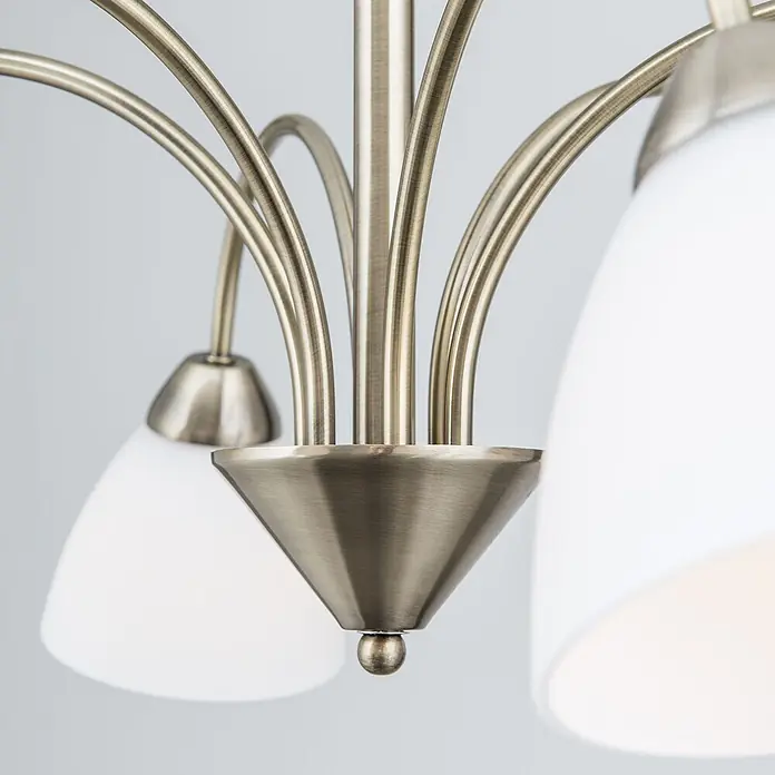 Orion Leuchten Pendelleuchte - L x B x H: 60 x 60 x 40 cm, E14 - Nahaufnahme eines Kronleuchters aus gebürstetem Messing mit mehreren geschwungenen Armen und weißen konischen Glasschirmen.