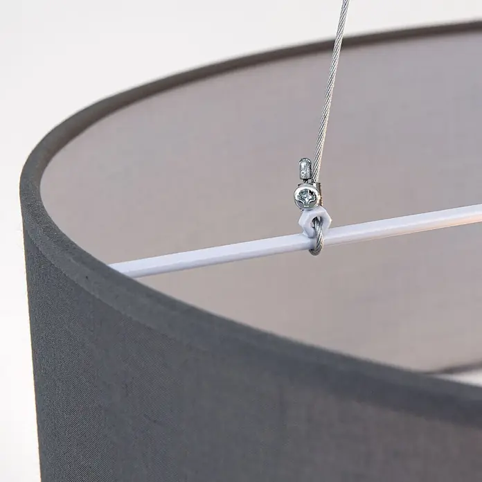 Orion Leuchten Pendelleuchte rund - E27 - Nahaufnahme eines grauen Stofflampenschirms mit weißer Stützstange und Aufhängeseil, befestigt mit einer Metallklemme.