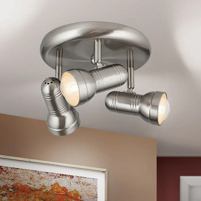 Orion Leuchten Deckenstrahler - L x B x H: 25 x 25 x 23 cm, E27 - Eine gebürstete Nickel-3-Flammen-Deckenleuchte mit verstellbaren Strahlern beleuchtet einen Raum und ein gerahmtes Kunstwerk.