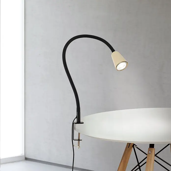 Orion Leuchten Klemmleuchte - 40 W, L x B x H: 7,5 x 24 x 58 cm - Verstellbare schwarze Schwanenhals-Klemmleuchte mit cremefarbenem Kopf, beleuchtet einen weißen Tisch.