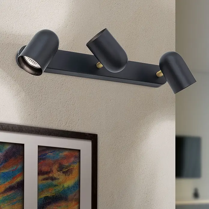 Orion Leuchten Deckenstrahler - L x B x H: 14 x 37 x 8,8 cm, GU10 - Verstellbare mattschwarze dreiflammige Schienenleuchte mit Messingakzenten, an einer Wand montiert.