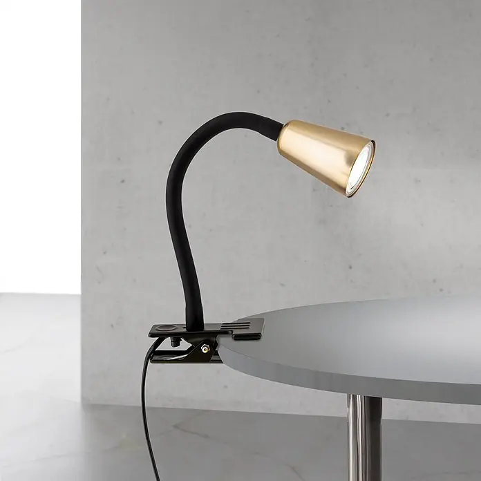 Orion Leuchten Klemmleuchte - 40 W, L x B x H: 7,5 x 16,5 x 27 cm - Schwarze Klemmleuchte mit flexiblem Arm und goldfarbenem Kopf, beleuchtet einen hellgrauen Rundtisch.