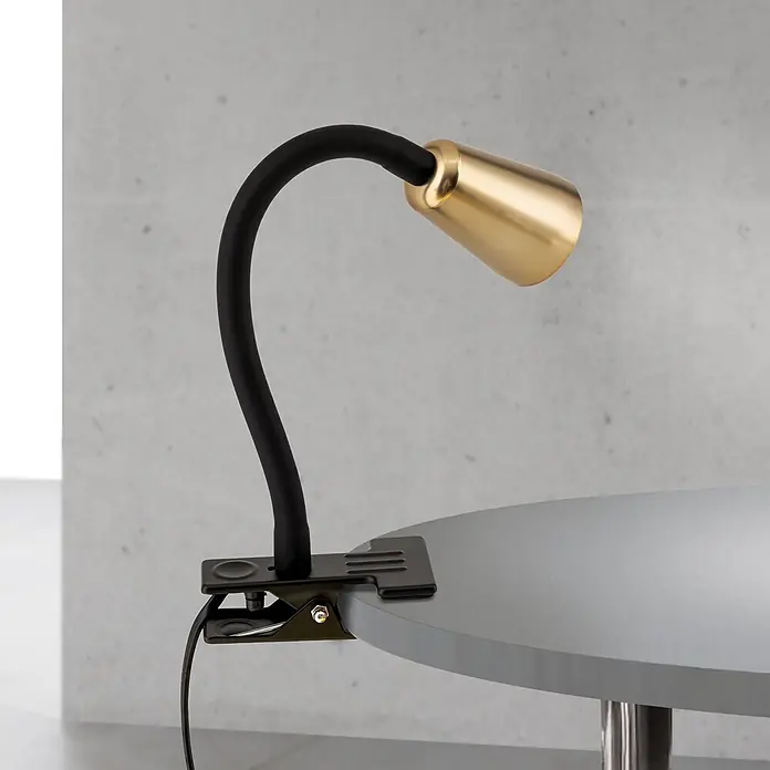 Orion Leuchten Klemmleuchte - 40 W, L x B x H: 7,5 x 16,5 x 27 cm - Schwarze Klemmleuchte mit flexiblem Arm und goldfarbenem Schirm, an einem grauen Tisch befestigt.