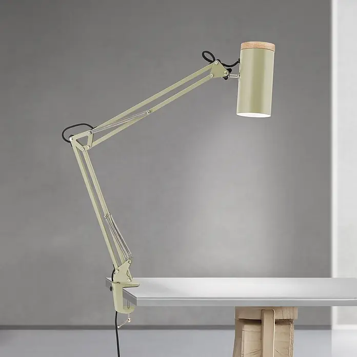 Orion Leuchten Klemmleuchte - 40 W, L x B x H: 55 x 8 x 86 cm - Verstellbare, salbeigrüne Klemm-Schreibtischlampe mit Federarm und zylindrischem Schirm mit Holzaufsatz, an einem Schreibtisch befestigt.