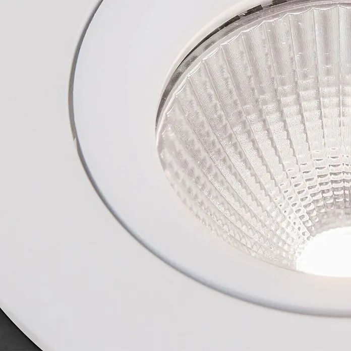 Orion Leuchten Einbauleuchte -  - Nahaufnahme eines weißen LED-Einbaustrahlers mit klarem, strukturiertem Reflektor und leuchtender Lichtquelle.