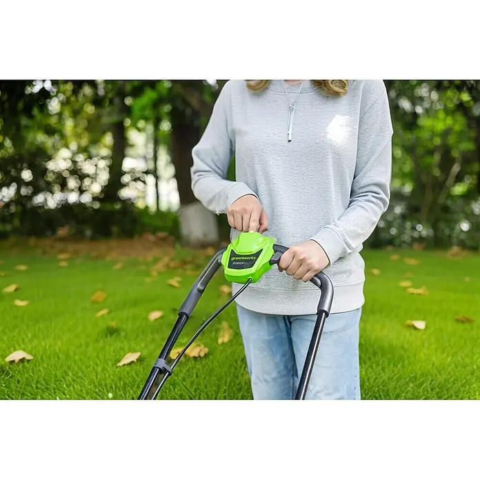 Greenworks Akku-Rasenmäher Gen2 GW 24V BL 4 AH 33 cm - 24 V, 1 Akku, 4 Ah, Schnittbreite: 33 mm - Person bedient grüne Greenworks POWERALL Rasenmäher-Steuerung im Garten.