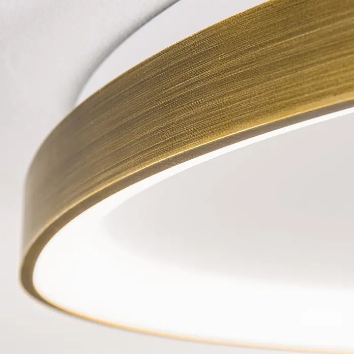 Orion Leuchten LED-Deckenleuchte - L x B x H: 65 x 65 x 6 cm - Nahaufnahme einer runden Leuchte mit gebürstetem messingfarbenem Metallring und weichem weißem Licht des Diffusors.