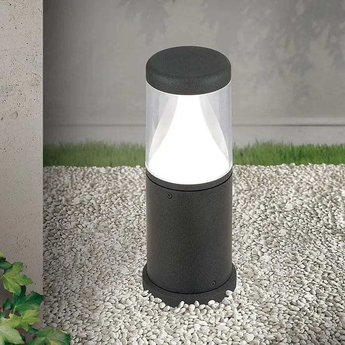 Orion Leuchten Außensockelleuchte - 12 x 12 x 30 cm, Mit Leuchtmittel - Dunkelgraue Outdoor-Pollerleuchte mit klarem Oberteil, weißes Licht spendend, auf weißen Kieselsteinen im Gartenweg.