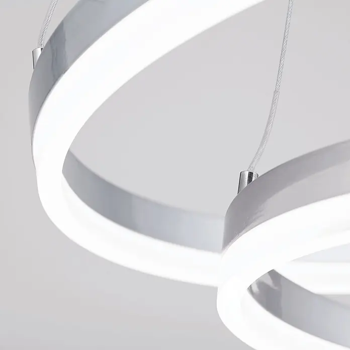 Orion Leuchten LED-Pendelleuchte rund -  - Moderne LED-Hängeleuchte mit verschlungenen weiß beleuchteten Ringen und silbergrauem Rahmen, aufgehängt an dünnen Drähten.