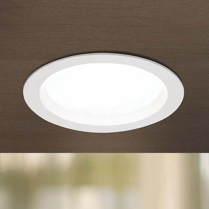 Orion Leuchten LED-Einbauleuchte rund -  - Weißer runder LED-Einbaustrahler in dunkler Holzdecke, beleuchtet den unscharfen Hintergrund darunter.