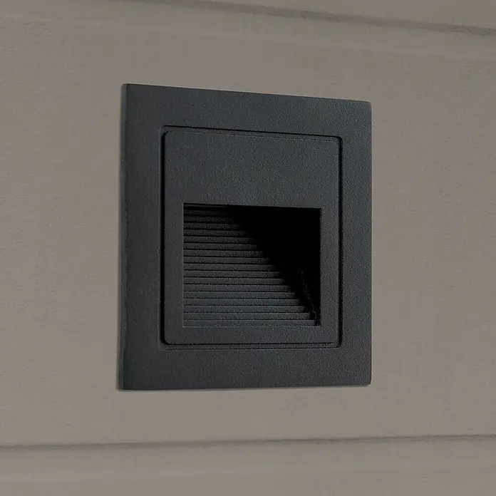Orion Leuchten LED-Einbauleuchte - L x B x H: 7,2 x 8,5 x 8,5 cm - Dunkelgraue rechteckige Einbau-Treppenleuchte mit horizontalen Lamellen, an strukturierter Wand montiert.