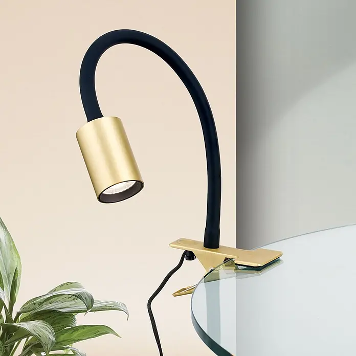 Orion Leuchten LED-Klemmleuchte - L x B x H: 46 x 6 x 12 cm, 5 W, Lichtfarbe: Warmweiß - Eine flexible Schwanenhals-Klemmleuchte mit goldenem Kopf und schwarzem Arm, an einem Glastisch befestigt.