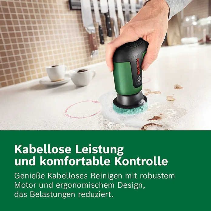 Bosch Akku-Reinigungsbürste Taydo - 3,6 V, 1 Akku, 6 -tlg. - Eine Hand hält eine grün-schwarze Bosch Reinigungsbürste und schrubbt Flecken von einer weißen Küchenarbeitsplatte.
