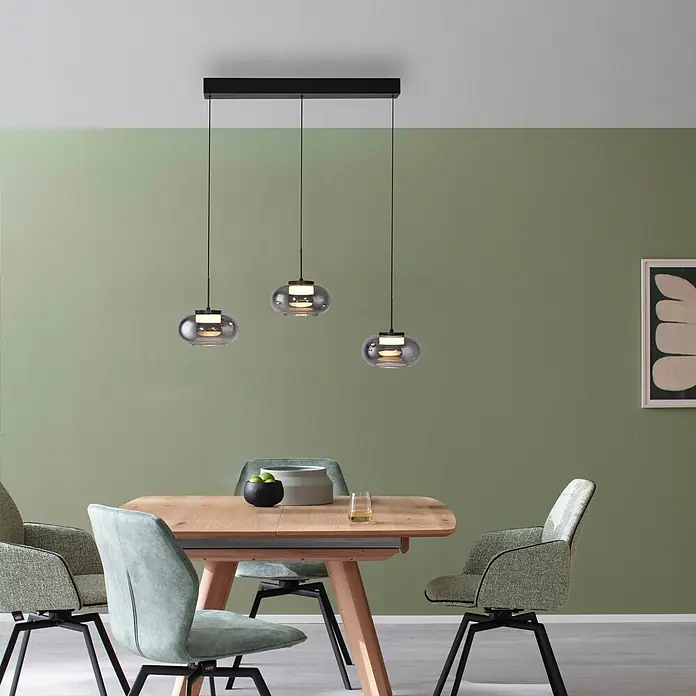 Just Light LED-Pendelleuchte Sia - 6 W, L x B x H: 80 x 75 x 20 cm, Rauchglas/ Schwarz, Warmweiß, Anzahl Leuchtmittel: 3 Stk. - Drei moderne Pendelleuchten aus Rauchglas mit schwarzer Stange über einem Holztisch und Polsterstühlen.
