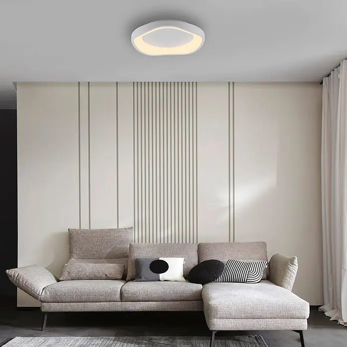 Just Light LED-Deckenleuchte rund Tavoli - 10 W, Ø x H: 28,5 x 7 cm, Sandbrise, Neutralweiß - Moderne weiße ovale Deckenleuchte mit warmem Licht, die ein Wohnzimmer über einem Sofa beleuchtet.