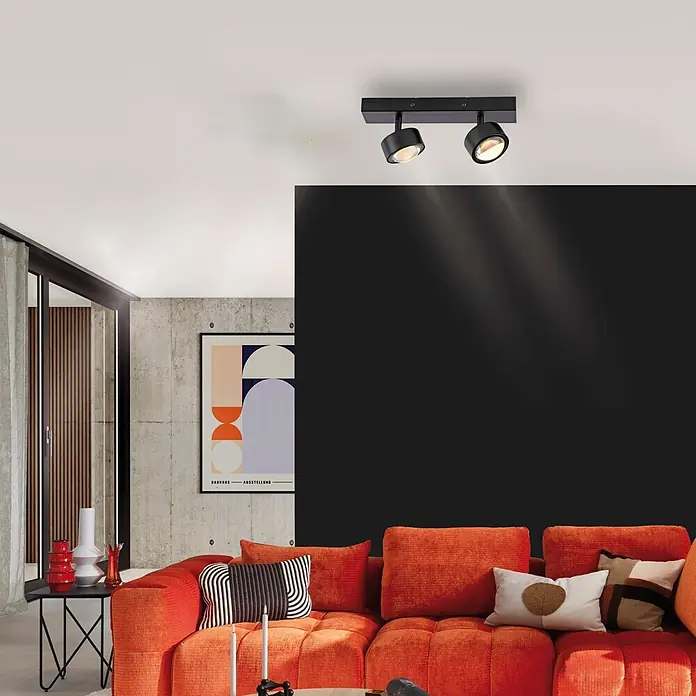 Just Light LED-Deckenstrahler Kulu - 9,6 W, L x B x H: 30 x 12 x 12,5 cm, Schwarz, Warmweiß, Anzahl Leuchtmittel: 2 Stk. - Schwarzer Deckenspot mit zwei verstellbaren Köpfen, der eine dunkle Wohnzimmerwand beleuchtet.