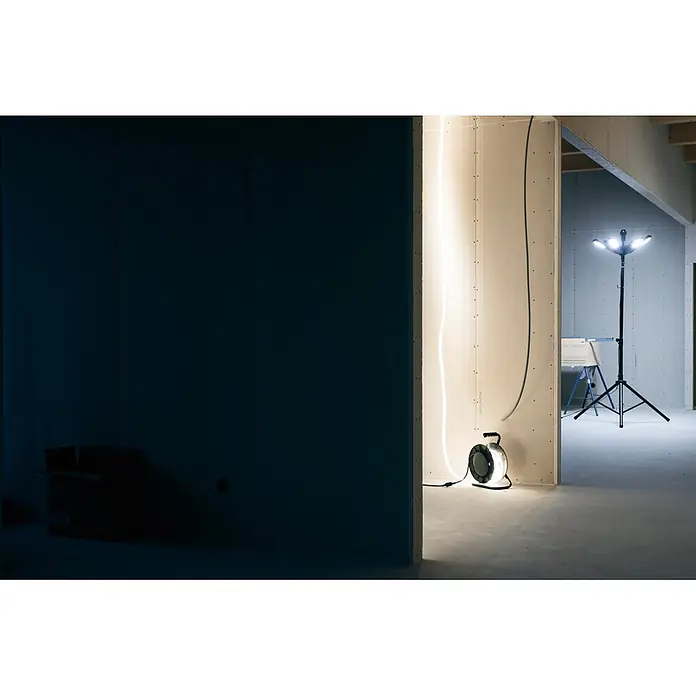 Mareld LED-Stripes Sunlit Pro - Länge: 25 m, Kaltweiß, Lichtstrom: 32.500 lm - Tragbare Arbeitsleuchten erhellen eine Baustelle; eine Trommelleuchte am Boden und ein Mehrkopf-Flutlicht auf einem Stativ.