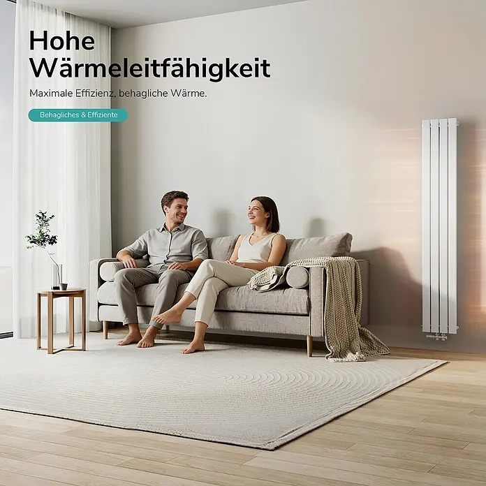 Emke Designheizkörper Flatrad FR - Wärmeleistung bei Vorlauftemperatur von 75 °C (D: 50): 627 W, Weiß - Hoher, weißer Plattenheizkörper wärmt ein modernes Wohnzimmer, in dem ein Paar auf einem Sofa entspannt.