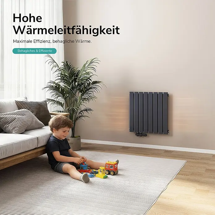 Emke Designheizkörper Flatrad FR - Wärmeleistung bei Vorlauftemperatur von 75 °C (D: 50): 450 W, Anthrazit - Dunkelgrauer vertikaler Paneelheizkörper an einer hellen Wand in einem Wohnzimmer, wo ein Kind spielt, betont effizientes Heizen.