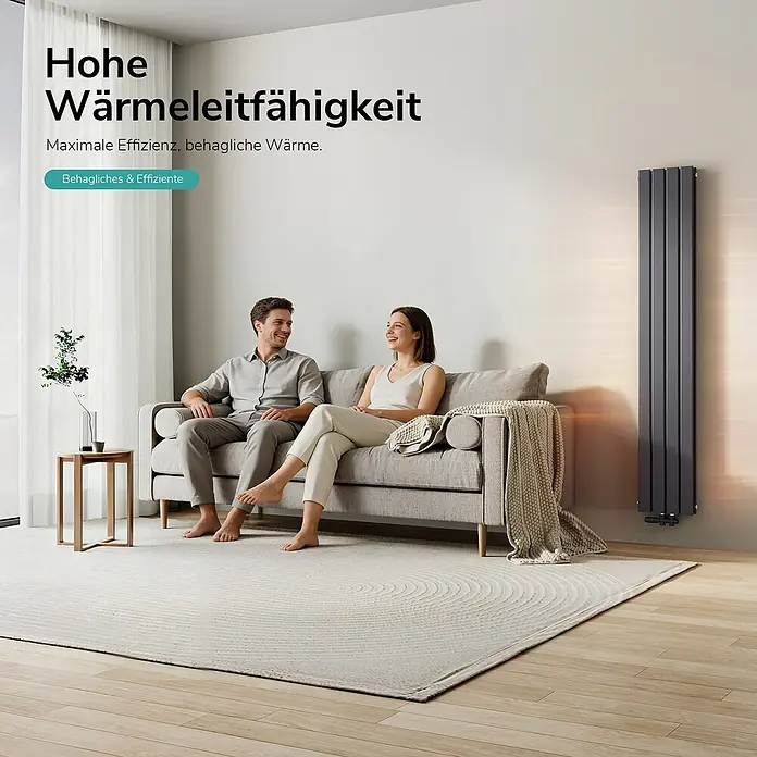 Emke Designheizkörper Flatrad FR - Wärmeleistung bei Vorlauftemperatur von 75 °C (D: 50): 911 W, Anthrazit - Ein Paar entspannt sich im Wohnzimmer mit einem modernen, hohen, dunkelgrauen Heizkörper, der effiziente Wärme spendet.