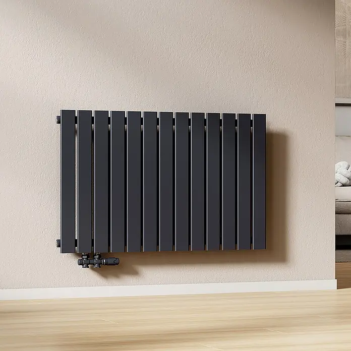 Emke Designheizkörper Flatrad FR - Wärmeleistung bei Vorlauftemperatur von 75 °C (D: 50): 730 W, Anthrazit - Dunkelgrauer Flachheizkörper mit schwarzen Ventilen, an einer hellen Wand installiert.