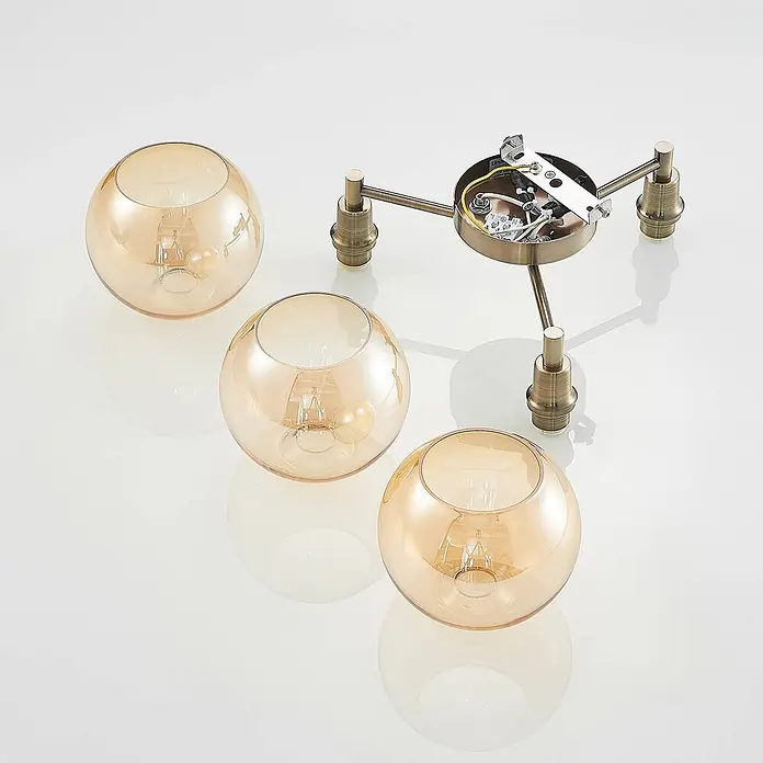 Lindby Deckenleuchte Jemissa - messing / gold, creme / amber, E14 - Zerlegte Deckenleuchte mit antikem Messingfuß und drei bernsteinfarbenen Glaskugelschirmen, je mit Glühbirne.