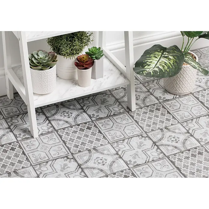 D-c-fix Bodenfliese Floor Tile Selbstklebend - 11 Stk., 30,5 x 30,5 cm, Moroccan Style - Grau-weiß gemusterte Bodenfliesen mit verschiedenen ornamentalen Mustern, auf einem Boden verlegt.