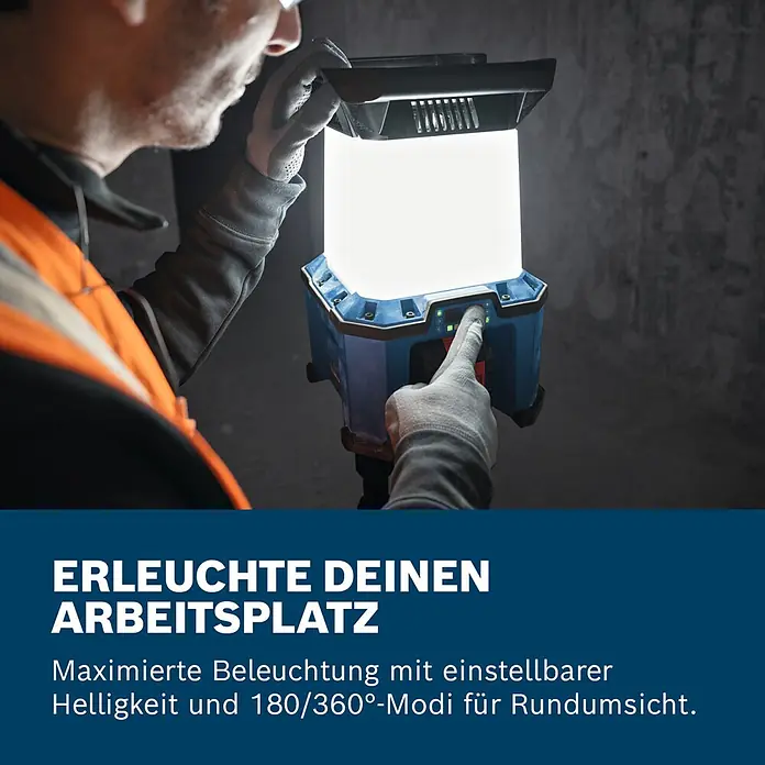 Bosch Professional AMPShare 18V Akku-Bauleuchte - 18 V, Anzahl Akkus: Ohne Akku, 7.500 lm - Eine Person in Arbeitshandschuhen bedient eine blau-schwarze Arbeitsleuchte, die helles Licht ausstrahlt, in einer dunklen Umgebung.