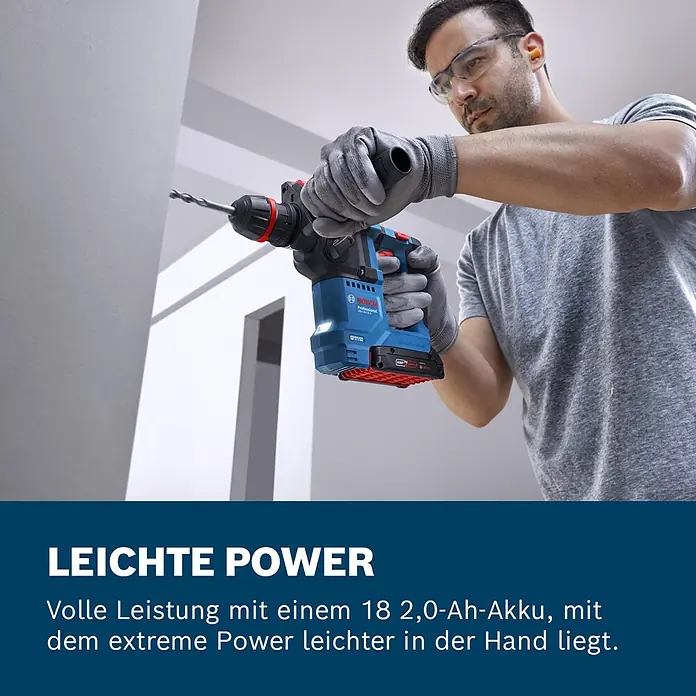 Bosch Professional AMPShare 18V Akku-Bohrhammer GBH 18V-18 X - 18 V, Ohne Akku, 1,5 J - Mann bohrt mit blau-rotem Bosch Akku-Bohrhammer und 18V 2,0Ah Akku in eine Wand.