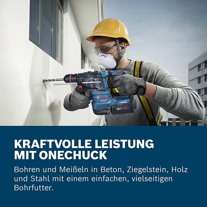 Bosch Professional AMPShare 18V Akku-Bohrhammer GBH 18V-22X - 18 V, Ohne Akku, 2 J - Eine Person mit Helm und Maske bohrt mit einem blauen Bosch Akku-Bohrhammer in eine weiße Wand.